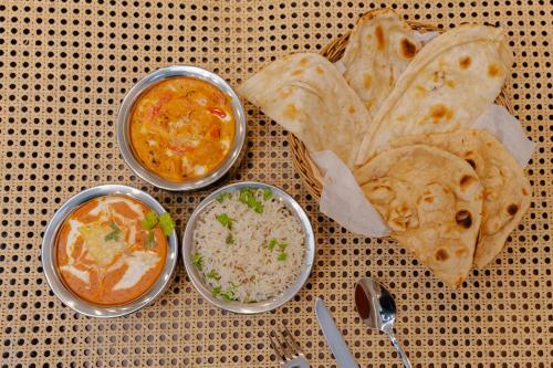 a table with three bowls of dip and some food at Alokah Kashi in Varanasi