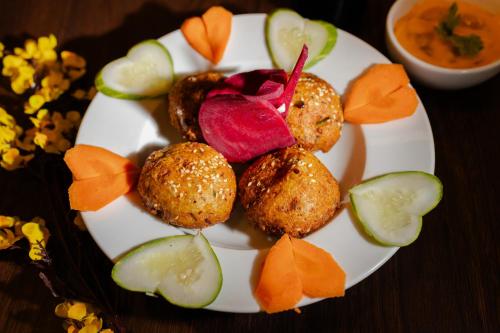 a plate of food with vegetables and dipping sauce at Alokah Kashi in Varanasi