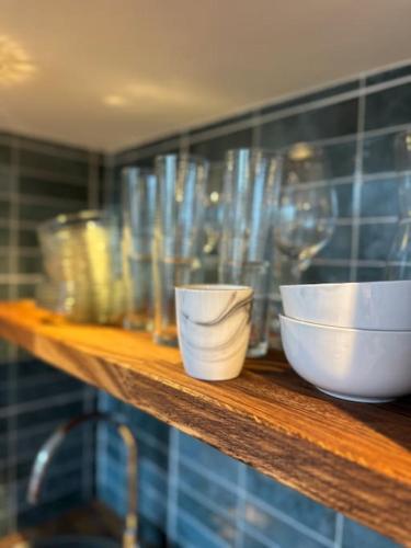 une étagère en bois avec des bols et des verres dans l'établissement Grand studio mezzanine cathédrale de Lisieux, à Lisieux