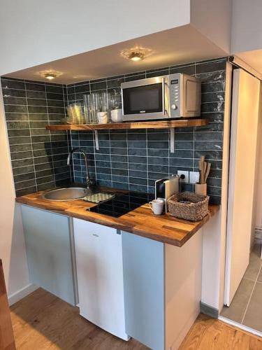 une cuisine avec un comptoir avec un micro-ondes dans l'établissement Grand studio mezzanine cathédrale de Lisieux, à Lisieux