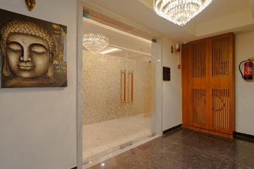 a bathroom with a statue of a head on the wall at Alokah Kashi in Varanasi