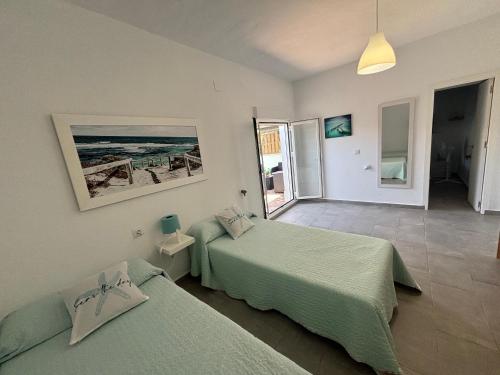 une chambre avec deux lits et une vue sur l'océan dans l'établissement Casa María Oliva 50m playa, à El Palmar