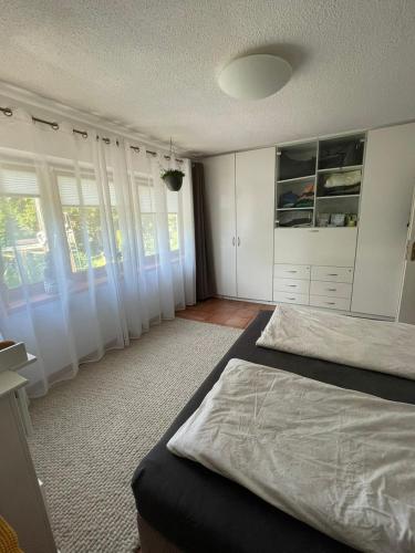 a bedroom with white cabinets and a large bed at Große Wohnung mit Whirlpool und Garten in Müllheim