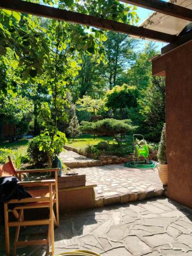a garden with a stone patio with a pergola at Guesthouse Silvani in Kruševac