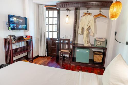 a bedroom with a bed and a desk and a chair at ANNAM HERITAGE - Thuy Duong 3 in Hoi An