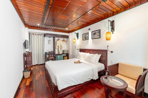 a bedroom with a bed and a table and chairs at ANNAM HERITAGE - Thuy Duong 3 in Hoi An