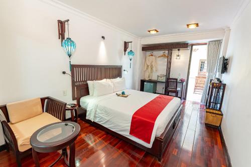a bedroom with a bed and a table and a chair at ANNAM HERITAGE - Thuy Duong 3 in Hoi An