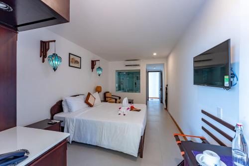 a bedroom with a bed and a table and a kitchen at ANNAM HERITAGE - Thuy Duong 3 in Hoi An