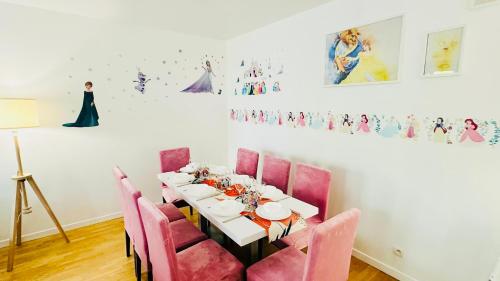 une salle à manger avec une table et des chaises roses dans l'établissement Mickey Mouse - Gare - Centre - Lac - Parking - Wifi, à Bussy-Saint-Georges
