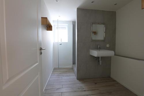 un baño con lavabo y espejo en DUINUNDER In de duinen, loopafstand naar 't strand, en Noordwijk aan Zee