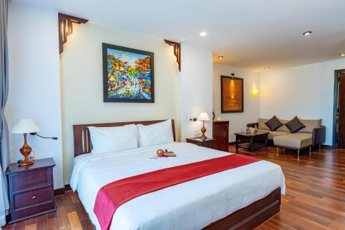 a bedroom with a large bed and a couch at ANNAM HERITAGE - Thuy Duong 3 in Hoi An