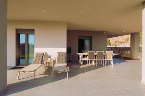 a room with chairs and tables on a patio at Blue Lagoon Villa in Stavros