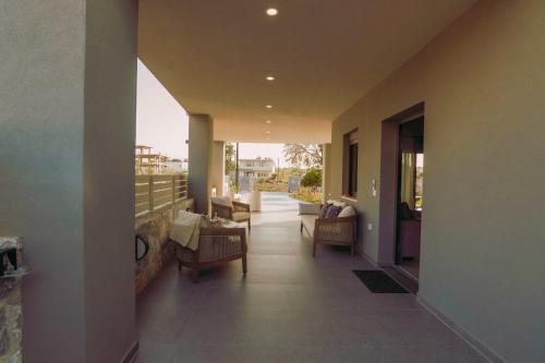 a hallway of a house with chairs and a balcony at Blue Lagoon Villa in Stavros