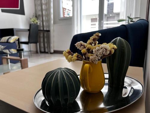 a table with a yellow vase and flowers on it at Central Stylish Apartment in Thessaloniki