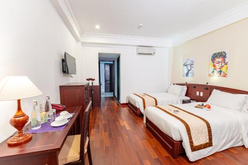 a hotel room with two beds and a table with a lamp at ANNAM HERITAGE - Thuy Duong 3 in Hoi An
