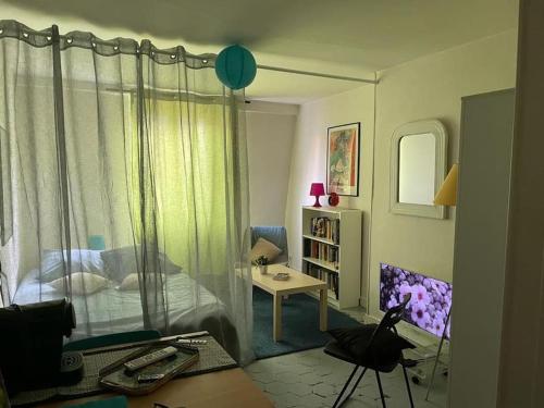 - une chambre avec un lit et une table dans l'établissement joli studio bohème sous les toits de Paris, à Paris