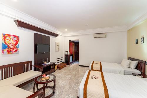 a hotel room with two beds and a tv at ANNAM HERITAGE - Thuy Duong 3 in Hoi An
