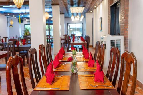 a long table in a restaurant with red napkins on it at ANNAM HERITAGE - Thuy Duong 3 in Hoi An
