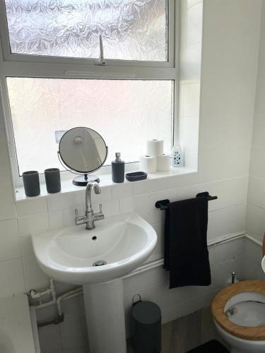 a bathroom with a sink and a mirror and a window at Prettide Suite Two-1 free Parking in Gillingham