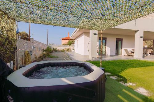 a large hot tub in the yard of a house at Blue Lagoon Villa in Stavros