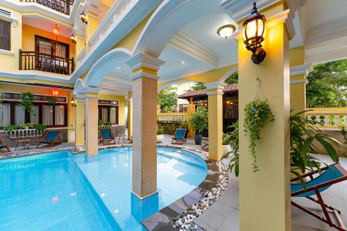 an indoor swimming pool in a building with a large ceiling at ANNAM HERITAGE - Thuy Duong 3 in Hoi An