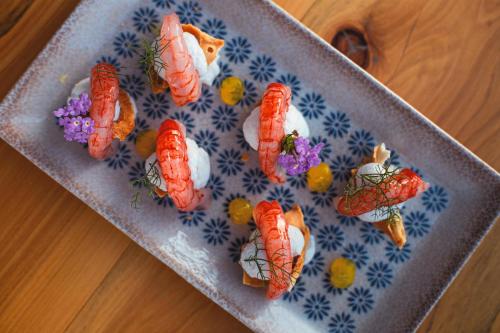 a plate of sushi with carrots on a table at Villa Totò Resort in Cefalù