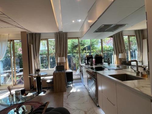 une cuisine avec un évier et une cuisinière four supérieur dans l'établissement Unique and Central I Garden in City Center, à Boulogne-Billancourt