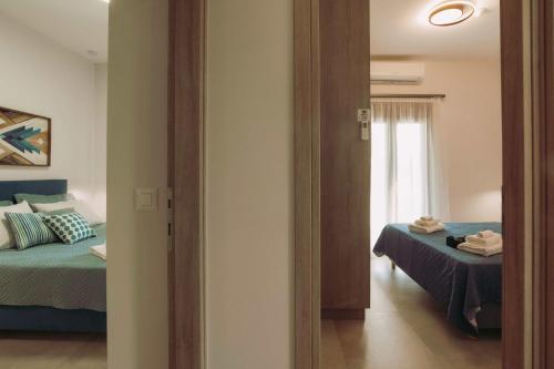 a room with two beds and a window and a mirror at Blue Lagoon Villa in Stavros