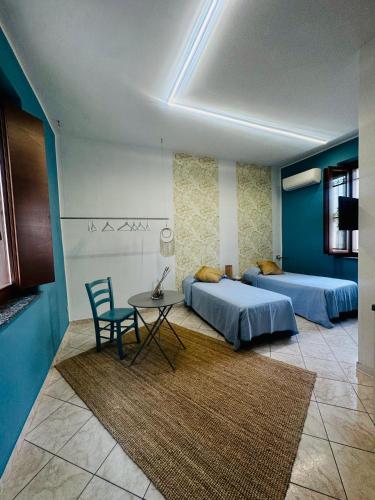 due letti in una stanza con un tavolo e una sedia di Vigevano Studios a Vigevano