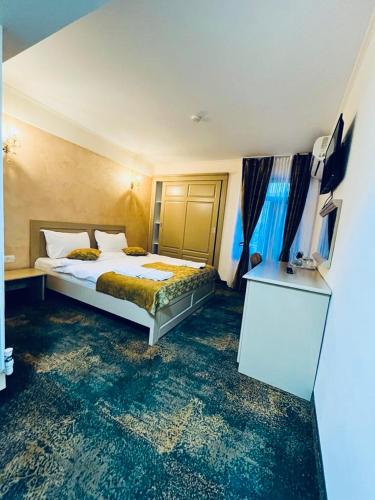 a hotel room with a bed and a dresser in it at Hotel La Ane in Babadau