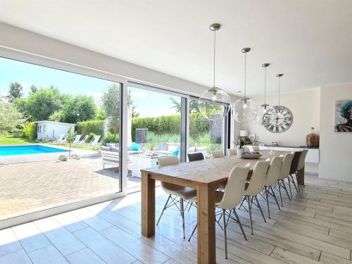 a dining room with a wooden table and chairs at Villa Blue Garden B&B Vlaamse Ardennen nabij Pairi Daiza in Geraardsbergen
