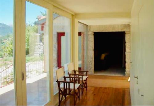 a room with chairs and a room with a large window at Gerês - Casa da Cabana in Vieira do Minho