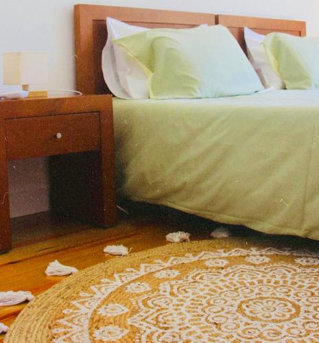 a bedroom with a bed and a nightstand with a green blanket at Gerês - Casa da Cabana in Vieira do Minho