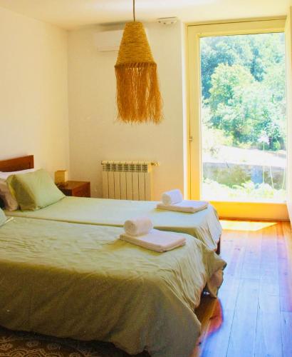 a bedroom with a bed and a large window at Gerês - Casa da Cabana in Vieira do Minho