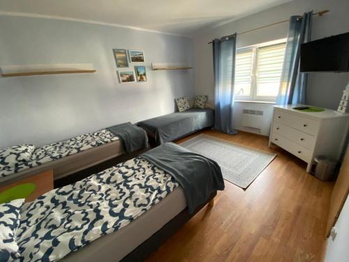 una camera da letto con due letti, un comò e una finestra di Nasze Morze a Dziwnów