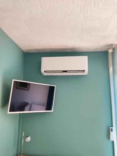 a ceiling with a television on a blue wall at studio du parc piscine in Souillac
