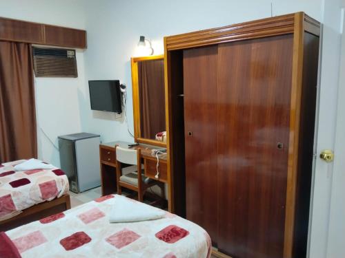 a room with two beds and a cabinet and a desk at Merry Land Hotel & Roof Top Nile Restaurant Luxor in Luxor