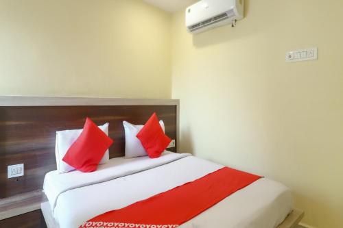 a bedroom with a bed with red and white pillows at Hotel O 67309 Hotel Tuk Tuk Palace in Rānchī