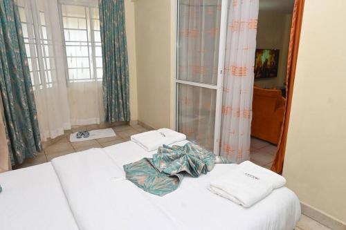 Кровать или кровати в номере Orange Deck 3 Bedroom Nanyuki