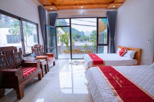 a bedroom with two beds and chairs and a large window at Trang An Nature View Homestay in Nguyên Ngoại
