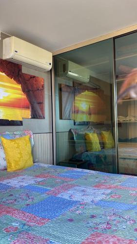 a bedroom with a bed with a colorful quilt on it at Luxor Paulo Miranda Frente ao mar in João Pessoa