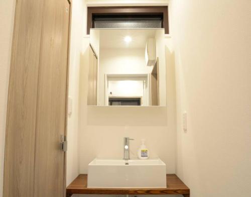 a bathroom with a white sink and a mirror at 高円寺中野Villa in Tokyo
