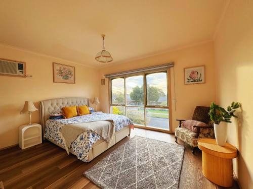 a bedroom with a bed and a large window at Oceanview 4B2B Two-story House with Big Balcony! in Frankston South
