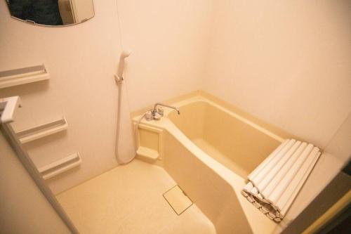 a small bathroom with a tub and a toilet at 横須賀マリンコテージハウス601 in Kusugaurachō