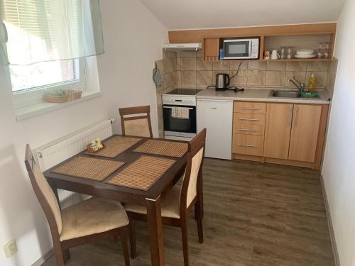 a kitchen with a table and chairs and a microwave at Penzion Na Potoce in Ledeč nad Sázavou