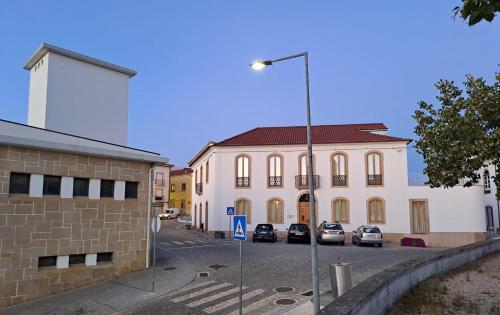a large building with cars parked in a parking lot at S Pedro Serta in Sertã