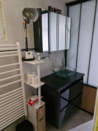 a bathroom with a sink and a desk with a mirror at Mon havre de paix in Blésignac