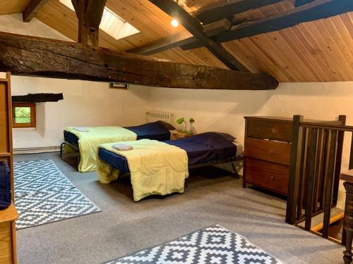 une chambre avec deux lits et un plafond en bois dans l'établissement Le Refuge des Bois, à Villandraut