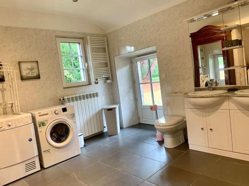 La salle de bains est pourvue d'un lave-linge, d'un lavabo et de toilettes. dans l'établissement Le Refuge des Bois, à Villandraut