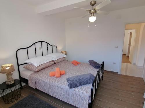 a bedroom with a bed with two orange pillows on it at House FIDULIĆ - apartment RUSTIC in Lumbarda